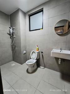 a bathroom with a toilet and a sink and a mirror at Sleek Cottage GLEN 1 HomeStay Kuching in Kuching