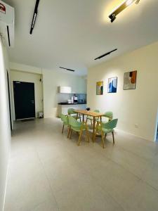 a dining room with a table and green chairs at Sleek Cottage GLEN 1 HomeStay Kuching in Kuching