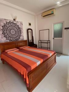 a bedroom with a bed with an orange comforter at Sunway Residence in Matara