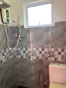 a bathroom with a shower and a pink toilet at Sunway Residence in Matara