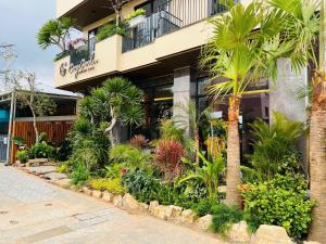 a building with a bunch of plants in front of it at Cozy Garden Boutique hotel in Khu Chi Lăng