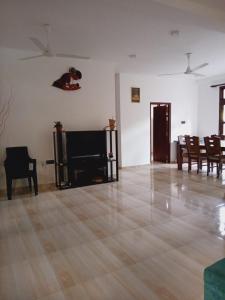 sala de estar con suelo de madera, TV y sillas en Devon Villa Hikkaduwa, en Hikkaduwa 18 fotos más