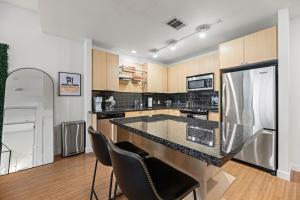 a kitchen with a large counter and chairs in it at Modern Downtown Dallas City View High-Rise, Free Parking, Pool, Gym in Dallas