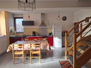 a kitchen with a table with chairs and a refrigerator at Le paradis des caves in Châteauvieux