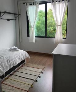 a bedroom with a bed and two large windows at 3 Bedrooms townhome, gated community KKC in Ban Si Than