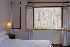 a bedroom with a bed and a large window at Hotel Iruya in Iruya