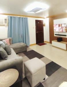 una sala de estar con un sofá y una silla en CJL TRANSIENT HOUSE B-Basak Lapu-lapu City Cebu,Mactan, en Lapu Lapu City