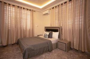 - une chambre avec un lit dans une chambre avec des rideaux dans l'établissement Agape Villa, à Sékondi