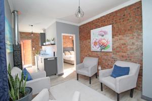 a living room with chairs and a brick wall at The Chameleon in Centurion