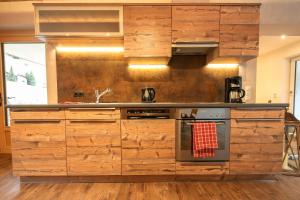 a kitchen with wooden cabinets and a stove at Chalet Alpinhome in Tux