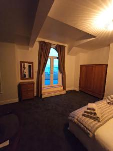 a bedroom with a bed and a large window at Comfortable family home with amazing Seaviews in Fleetwood