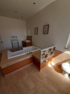 a bathroom with a bath tub and a toilet at Comfortable family home with amazing Seaviews in Fleetwood +35 photos