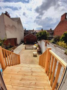 a wooden staircase leading to a patio with benches at Comfortable family home with amazing Seaviews in Fleetwood