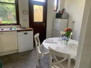 a kitchen with a table and a white table and chairs at Holiday Home with free parking & 4min to Edinburgh Warverly in Fisherrow