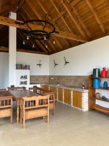 a large kitchen with a wooden table and benches at Gyöpszer Gyöngye Vendégház in Rádócújfalu