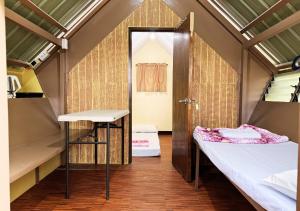 a small room with two beds and a door at Felicitas Tagaytay in Tagaytay