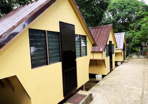 a yellow building with a black door and windows at Felicitas Tagaytay in Tagaytay