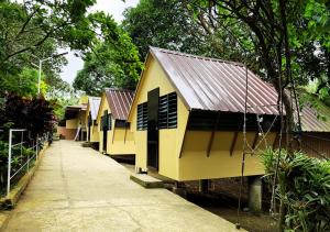 a row of yellow buildings with a sidewalk and trees at Felicitas Tagaytay in Tagaytay