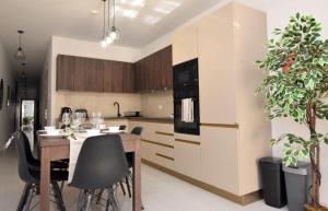 a kitchen with a wooden table and black chairs at 2 bedroom Flat close to Valletta & Sliema - Orion3 in Msida