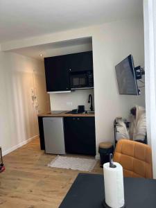 a living room with a kitchen and a couch at Appartement plein centre ville d alfortville in Alfortville