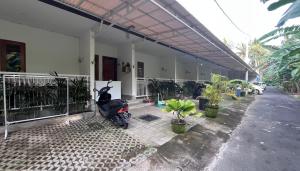 a scooter parked outside of a house with plants at Maisaba Living Sibang Gede in Bringkit