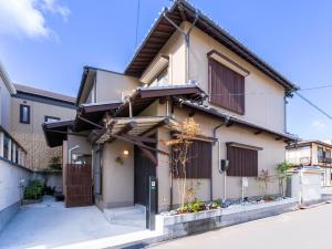 a house with brown shutters on a street at お宿Gａｎ錦町 in Takamatsu