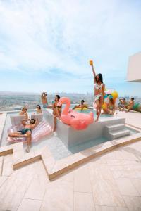 a group of people sitting around a pool at FIVE Jumeirah Village in Dubai
