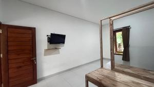 a room with a mirror and a tv on a wall at Maisaba Living Sibang Gede in Bringkit
