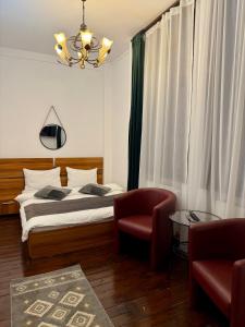 ein Schlafzimmer mit einem Bett, einem Stuhl und einem Kronleuchter in der Unterkunft Pension Casa del Sol Predeal in Predeal