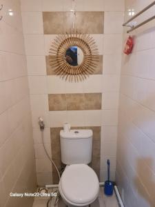 a bathroom with a toilet and a mirror at Mountain View at The Edge in Cimindi-hilir