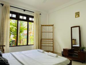 a bedroom with a bed and a large window at Bernard Homestay in Kandy