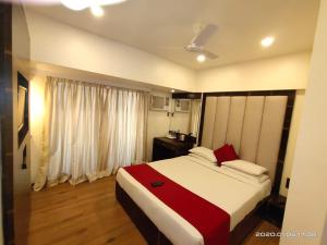 a bedroom with a large bed and a window at Hotel Heritage Dakshin in Navi Mumbai
