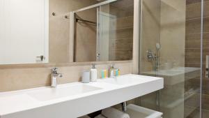 a bathroom with a white sink and a shower at SUNSET WAVES sea & sky apartment in Benidorm