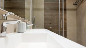 a bathroom with a shower and a white sink at SUNSET WAVES sea & sky apartment in Benidorm