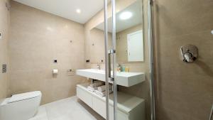 a bathroom with a toilet and a sink and a shower at SUNSET WAVES sea & sky apartment in Benidorm