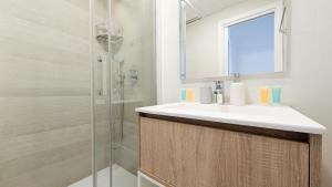a bathroom with a sink and a shower at SUNSET WAVES sea & sky apartment in Benidorm
