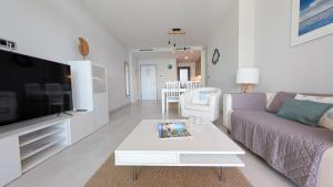 a living room with a couch and a tv at SUNSET WAVES sea & sky apartment in Benidorm