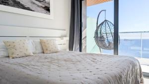 a bedroom with a bed and a large window at SUNSET WAVES sea & sky apartment in Benidorm