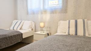 a bedroom with two beds and a window at SUNSET WAVES sea & sky apartment in Benidorm