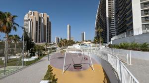 a playground in a city with tall buildings at SUNSET WAVES sea & sky apartment in Benidorm