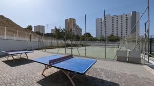 a tennis court with a table and a tennis racket at SUNSET WAVES sea & sky apartment in Benidorm