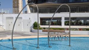a swimming pool with a sign that reads cutoff waves at SUNSET WAVES sea & sky apartment in Benidorm