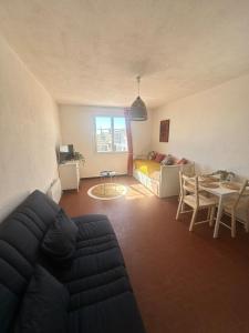 a living room with a couch and a table at Studio en plein cœur du village in Saintes-Maries-de-la-Mer