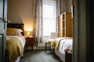 a bedroom with two beds and a window at Docker's Digs in Gateshead