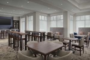 a restaurant with tables and chairs and a flat screen tv at Hilton Garden Inn Atlanta North/Johns Creek in Johns Creek
