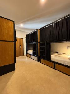a room with two bunk beds and a hallway at Lay Day Hostel Canggu in Canggu