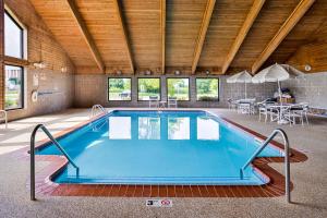a swimming pool in a building with a table and chairs at Quality Inn Bolingbrook I-55 in Bolingbrook