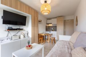 a living room with a couch and a table at Studio Cosy Les Myrtilles P2000 in Bolquere Pyrenees 2000