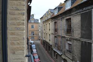 an alley in a city with cars parked on the street at DIEPPE GITES BEAUREGARD in Dieppe