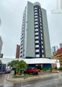 a red truck parked in front of a large building at Flat hotel number one 403 in São Luís